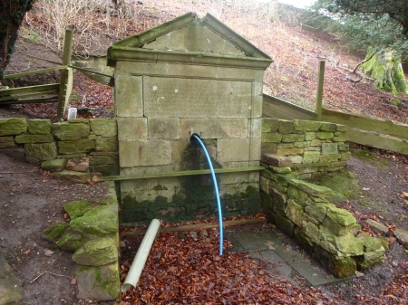 A neoclassical fountain with Latin inscription in the gardens of Penicuik House
