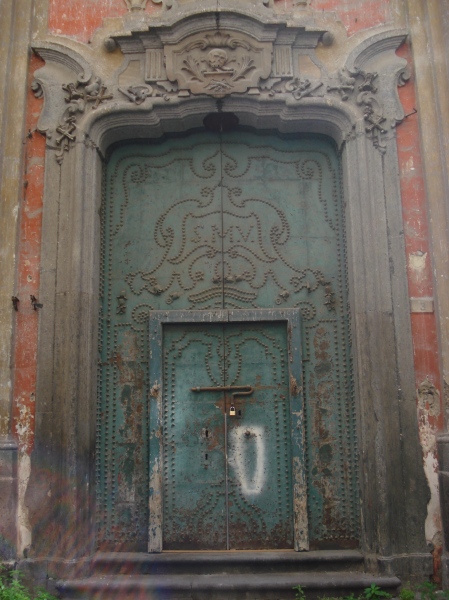 The wonderfully Baroque main door to an empty church in Naples